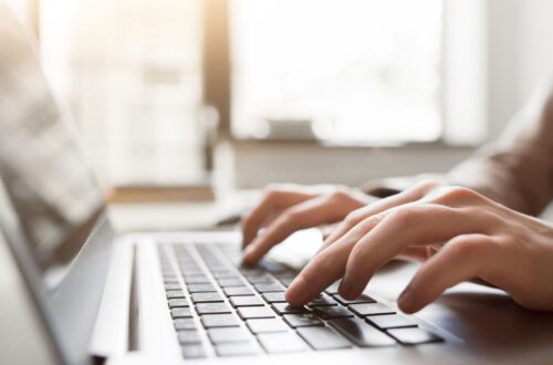 Haende tippen auf Laptop im hellen Buero, symbolisch fuer ghostwriter bachelorarbeit und professionelle Schreibunterstuetzung